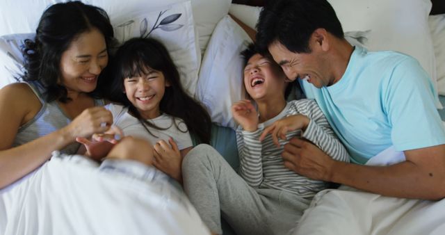 Happy Family Laughing and Bonding Together in Bed on Weekend Morning - Download Free Stock Images Pikwizard.com