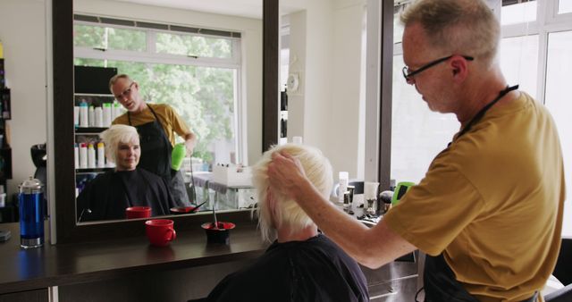 Senior Hairstylist Adjusting Blond Hair in Modern Hair Salon - Download Free Stock Images Pikwizard.com