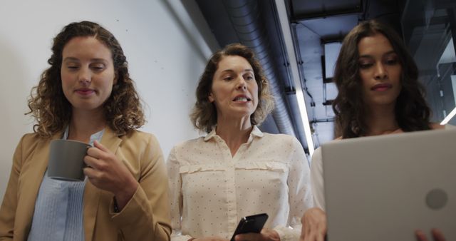 Three Businesswomen Collaborating in Modern Office Hallway - Download Free Stock Images Pikwizard.com