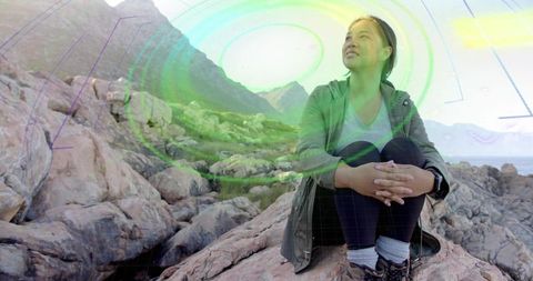 Asian Woman on Rocky Coast with Virtual Interactive Technology Display