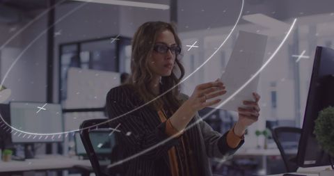 Businesswoman analyzing documents in modern office environment
