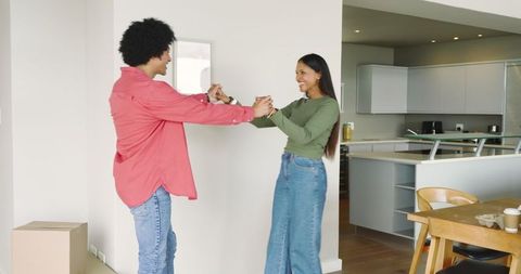 Diverse Couple Dancing in Modern Kitchen Celebration