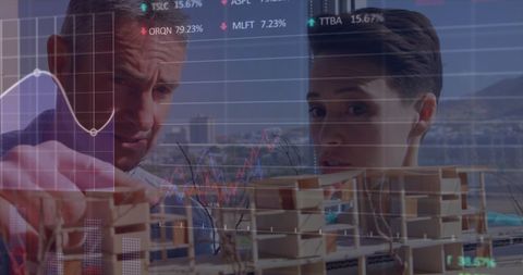 Architects analyzing building models with stock market data overlay