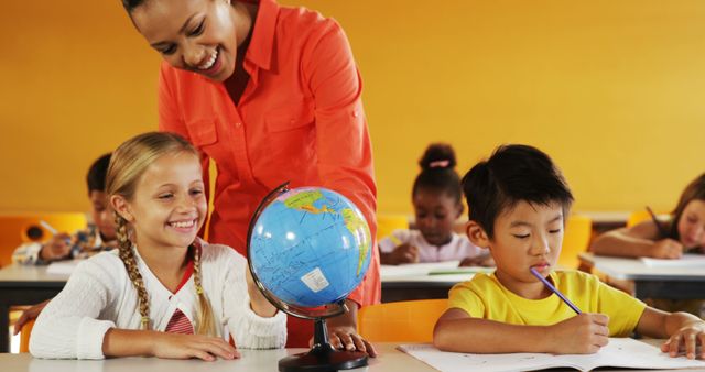 Smiling Teacher Helping Diverse Students Learning with Globe in Classroom - Download Free Stock Images Pikwizard.com