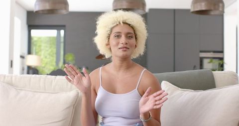Enthusiastic Woman with Curly Hair Engaged in Conversation at Home