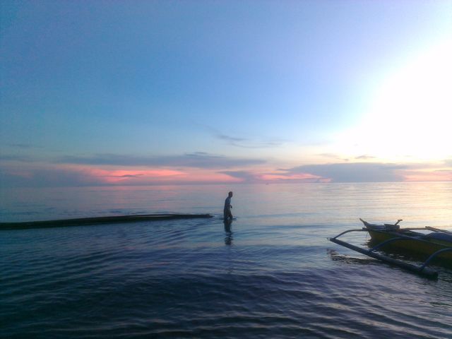 Person walking in calm sea at sunset - Download Free Stock Photos Pikwizard.com