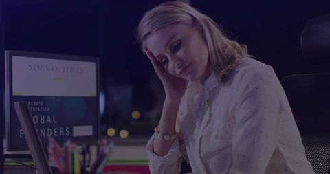 Businesswoman feeling stressed at office desk in evening