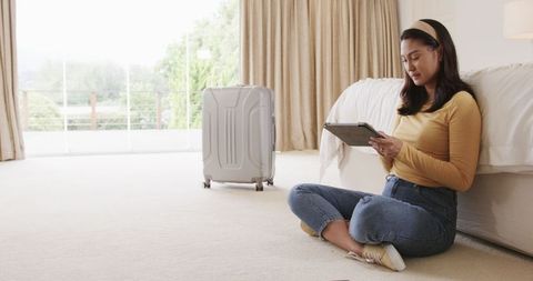 Woman booking travel online with tablet in cozy home surrounding
