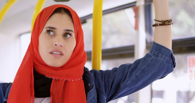 Young Woman in Red Hijab Holding Rail on Public Bus - Download Free Stock Images Pikwizard.com