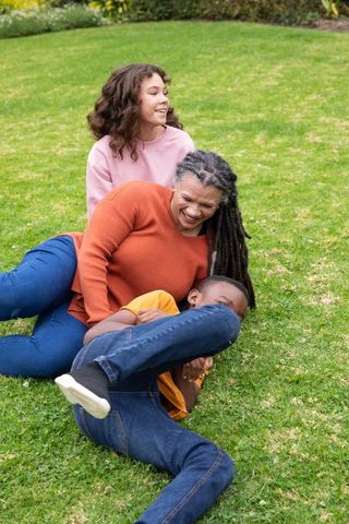 Happy family playing on grass lawn on sunny day