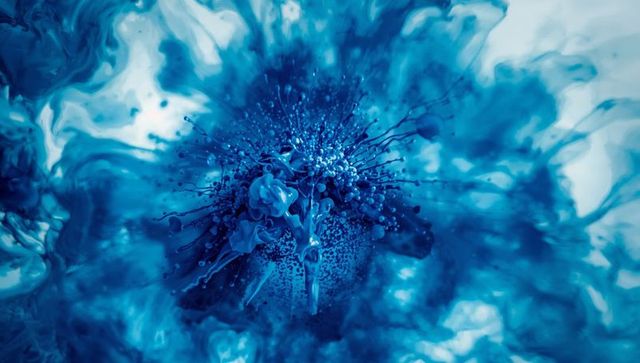 Dynamic blue liquid explosion surrounded by splashes