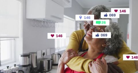 Senior Couple Embracing at Home Surrounded by Social Media Icons
