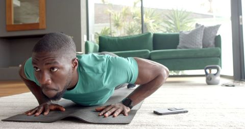 Motivated Man Doing Push-Ups in Modern Home Interior