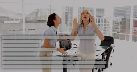 Two colleagues arguing and gesturing during tense meeting in modern high-rise office