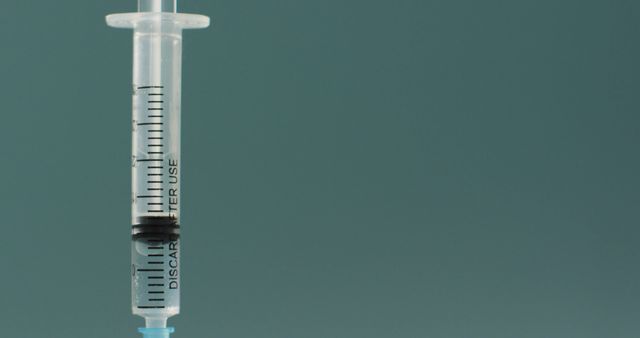 Close-Up of Medical Syringe with Clear Liquid on Turquoise Background - Download Free Stock Images Pikwizard.com