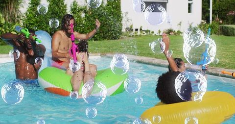 Diverse Friends Enjoying Splashing and Relaxing in Pool with Inflatables