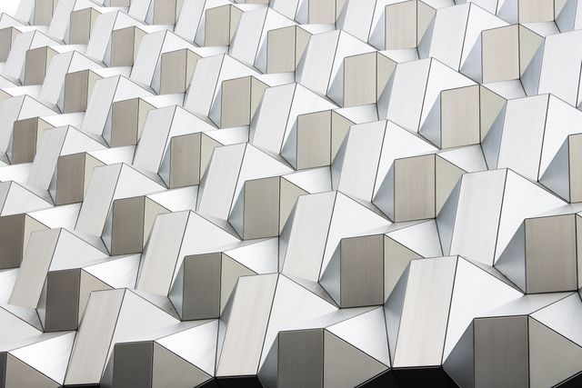 Complex 3D geometric pattern on a modern building facade. Used for architecture visuals, design inspiration, academic presentations on contemporary design, magazine covers, or even promotional materials for architectural firms.