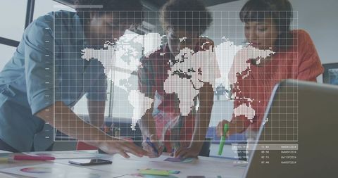 Young Team Collaborating Around Table with World Map Data Overlay for Global Planning Analytics