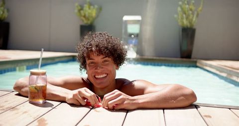 Joyful Young Adult Relaxing by Pool with Refreshing Beverage - Download Free Stock Images Pikwizard.com
