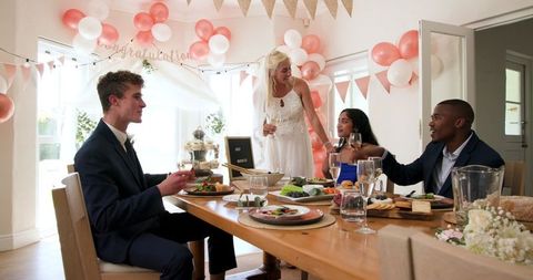 Multiracial Wedding Celebration with Bride, Groom, and Friends Dining