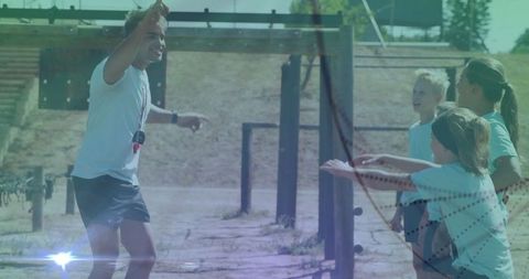Energetic Coach Leads Children Through Outdoor Obstacle Training