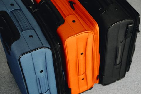 Three brightly colored suitcases prepared for travel