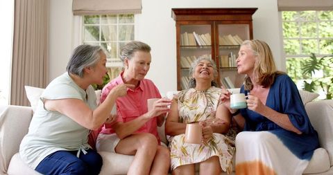 Diverse Middle-Aged Women Laughing Over Coffee at Home