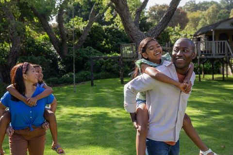 Joyful Family Enjoying Playful Moments in Sunlit Backyard