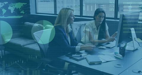 Cooperative Businesswomen Analyzing Data at Computer Desk