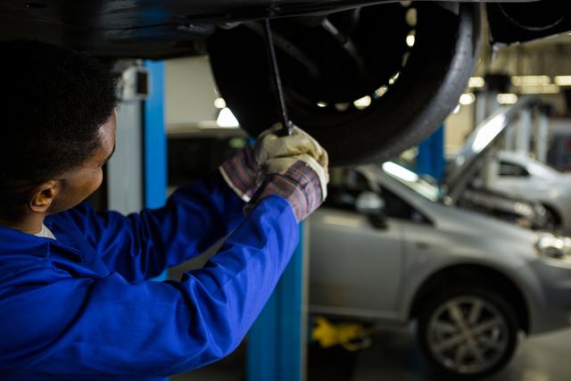Mechanic fixing a car tyre - Download Free Stock Photos Pikwizard.com