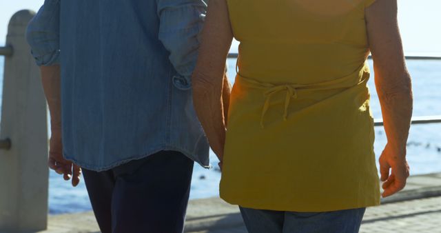 Senior caucasian couple holding hands and walking by sea. Retirement, relationship, love, togetherness, free time and relaxing, unaltered.