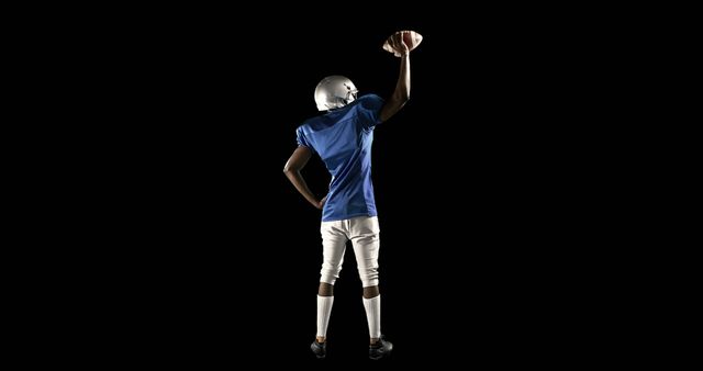 African American Football Player Holding Ball Triumphantly on Black Background - Download Free Stock Images Pikwizard.com