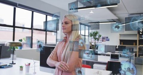 Professional woman standing in office viewing holographic ar dashboards with wind turbine