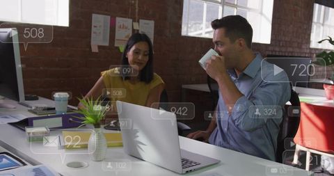 Colleagues collaborating at laptop in modern open-plan office with UI overlays