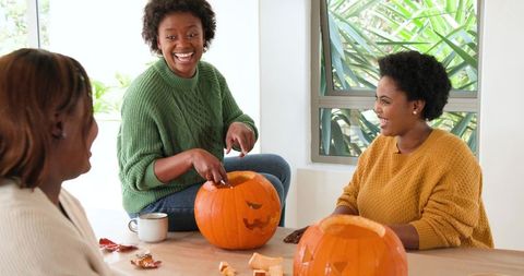 Friends Enjoying Pumpkin Carving Together at Home