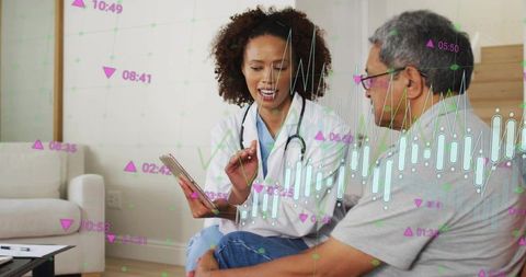 Doctor explaining digital health data to senior patient on sofa showing interactive charts