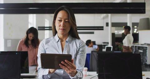 Businesswoman Reading Tablet in Modern Open Office for Team Collaboration