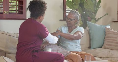 Caring nurse checking vital signs of senior woman at home