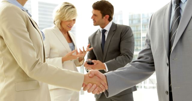Depicts businesspeople shaking hands while engaging in a discussion. Ideal for illustrating professional interactions, business agreements, successful partnerships, and collaborative environments. The image shows professionalism and collaboration, suitable for websites, presentations, and marketing materials aimed at corporate and business themes.
