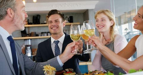 Business Colleagues Toasting with Wine During Meal at Restaurant
