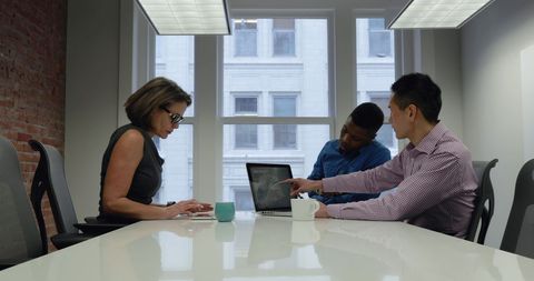 Corporate Team Collaborating on Laptop in Modern Office