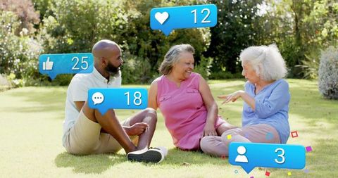 Intergenerational friends chatting on sunny lawn with social media reaction icons