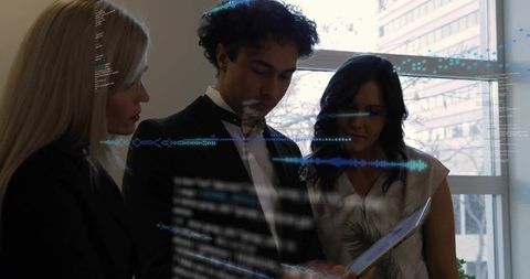 Business team collaborating with holographic data interface on tablet in modern office