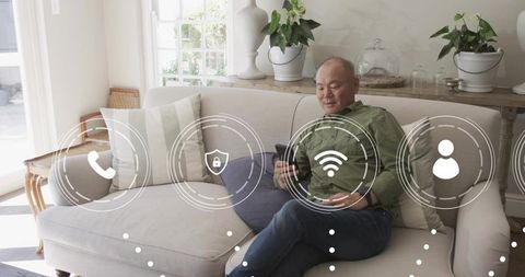 Mature man using smartphone on modern couch with smart home wifi icons and relaxed vibe