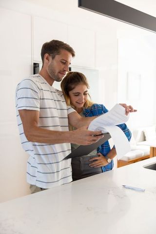 Couple Reviewing Home Documents in Modern Kitchen