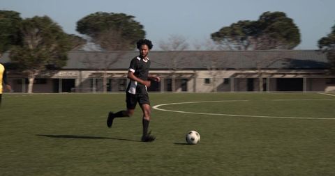 Athletic Soccer Player Dribbles on Field in Intense Match