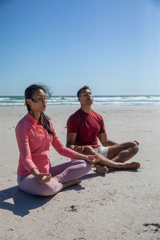 Diverse Couple Meditating on Beach Embracing Tranquility