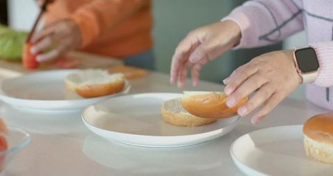 Couple preparing sandwiches on kitchen counter, teamwork in casual home cooking