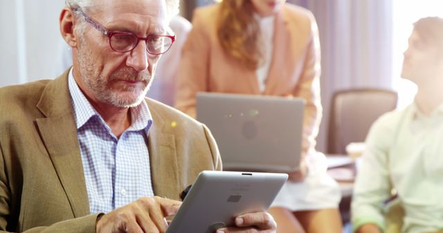 Senior Professional Using Tablet in Modern Office Environment - Download Free Stock Images Pikwizard.com