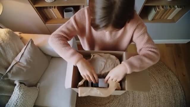 Child Discovering Sneakers from Unboxing Parcel at Home